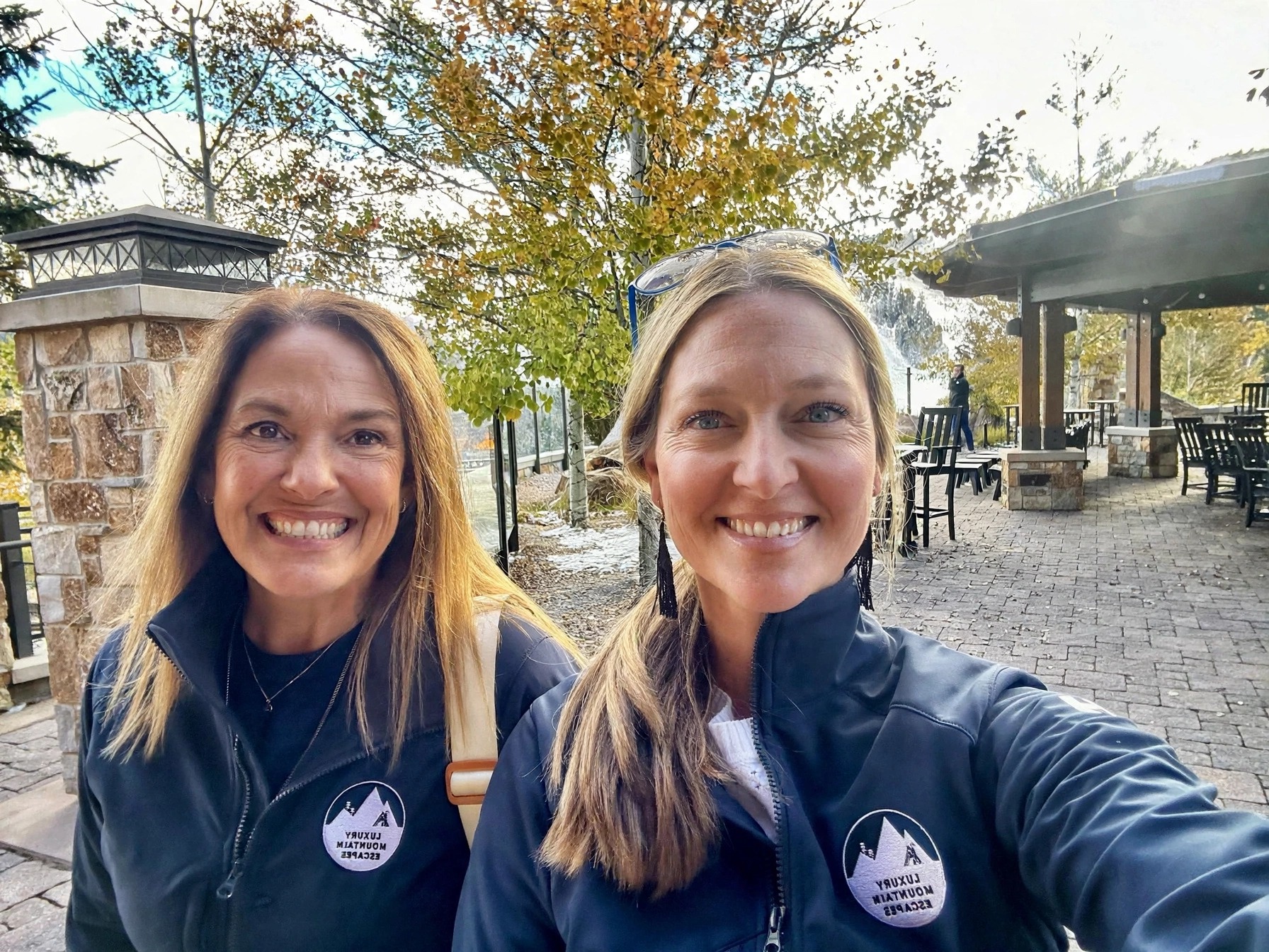 Amy and Tiffany, founders of Luxury Mountain Escapes, wearing branded jackets outdoors in Park City